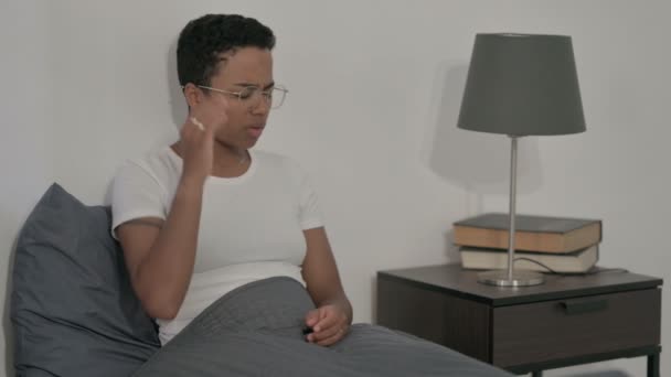 Африканська жінка з головним болем під час сидіння в ліжку — стокове відео
