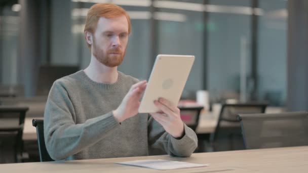 Молодой человек использует планшет во время работы в офисе — стоковое видео