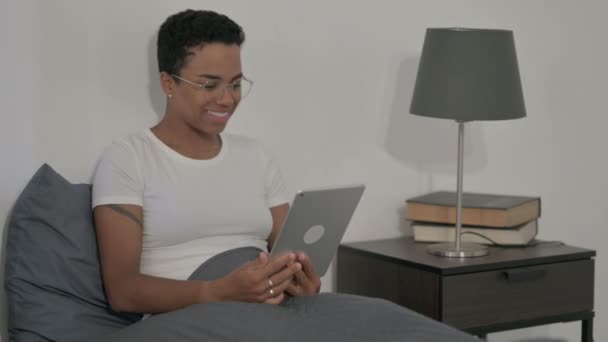ベッドでタブレットでビデオ通話を行うアフリカの女性 — ストック動画