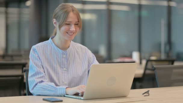 Młoda kobieta mówi na wideo Połączenie na laptopie w biurze — Wideo stockowe