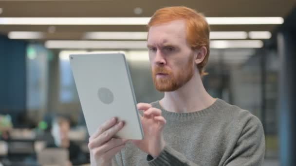 Portret van een jonge man met verlies op de tablet in het kantoor — Stockvideo