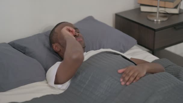 Aufgebrachter Afrikaner liegt weinend im Bett — Stockvideo