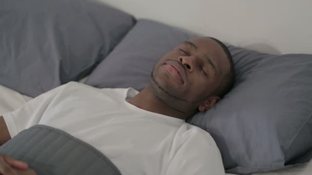 Afrikai férfi békésen alszik az ágyban. — Stock videók