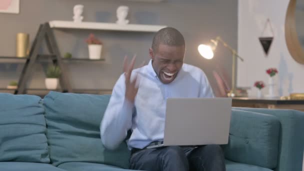 Hombre africano se siente sorprendido mientras se utiliza el ordenador portátil — Vídeos de Stock