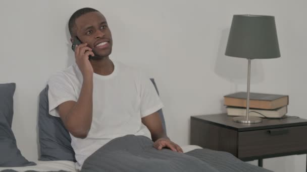 African Man Μιλώντας για κλήση στο Smartphone στο κρεβάτι — Αρχείο Βίντεο