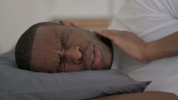 Közelkép afrikai férfi, amelynek nyaki fájdalom, miközben alszik az ágyban — Stock videók