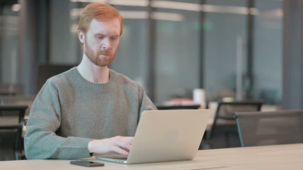 Mladý muž se cítí šokován při používání notebooku v kanceláři — Stock video