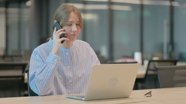Angry Woman Beszél Smartphone használata közben Laptop az irodában — Stock videók