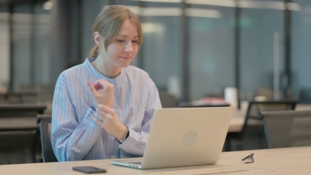 Junge Frau hat Schmerzen am Handgelenk, während sie Laptop im Büro benutzt — Stockvideo