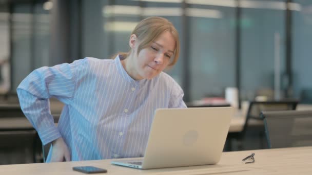 在办公室使用笔记本电脑时背痛的年轻女性 — 图库视频影像