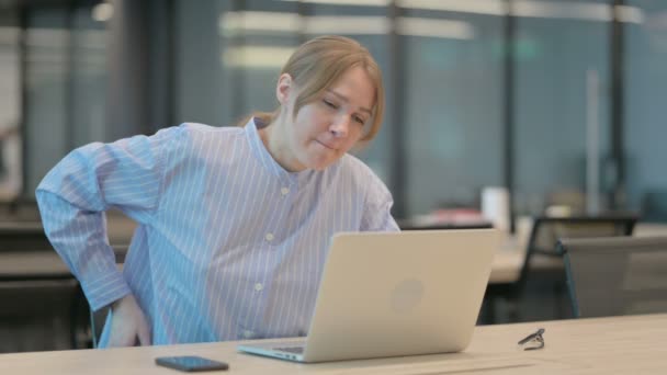 Young Woman having Back Pain while using Laptop in Office — Stock Video