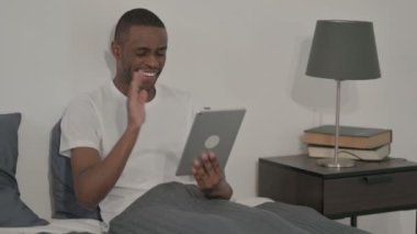 Afrikalı Adam Yatakta Otururken Tablet 'te Video Çağrısı Yapıyor