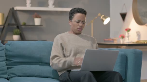 Afrikansk kvinna med laptop hosta på soffan — Stockvideo