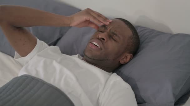 Africano que tem dor de cabeça enquanto dorme na cama, close-up — Vídeo de Stock