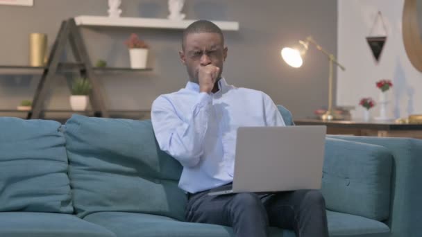 African Man with Laptop Coughing on Sofa — Stock Video