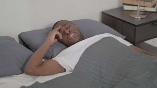 African Man ma ból głowy podczas snu w łóżku — Wideo stockowe