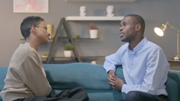 Casal tendo uma conversa séria enquanto sentado no sofá — Vídeo de Stock