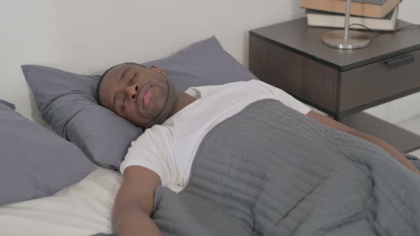 Un bărbat african are dureri de spate în timp ce doarme în pat — Videoclip de stoc