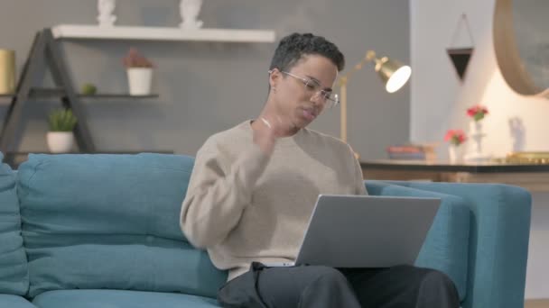 Donna africana con computer portatile con dolore al collo sul divano — Video Stock