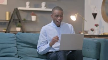 Dizüstü bilgisayarlı Afrikalı Koltukta Başarı Kutlaması 