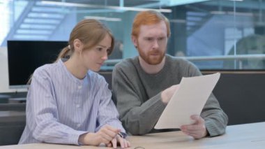 Genç Adam ve Kadın Ofiste Belge Okuyorlar 