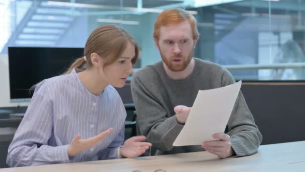 Jeune homme et jeune femme ayant une perte en lisant des documents — Video