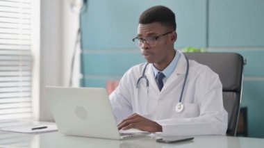 Ofisteki dizüstü bilgisayarda çalışan genç Afrikalı Doktor