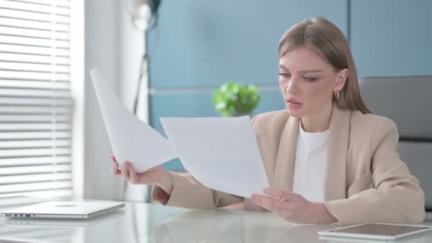 Mujer de negocios leyendo informes mientras está sentada en la oficina — Vídeo de stock