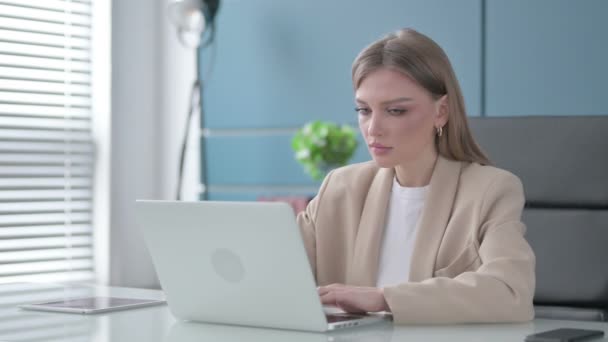 Бизнесвумен, работающая над ноутбуком в офисе — стоковое видео