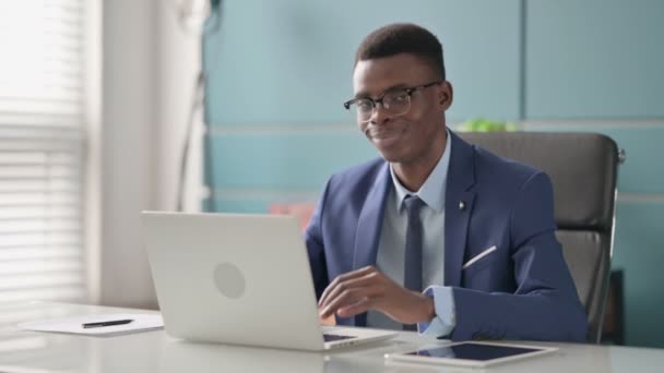 Νεαρός Αφρικανός Επιχειρηματίας Εμφανίζει Αντίχειρες Μέχρι Εγγραφείτε Ενώ χρησιμοποιείτε Laptop στο Γραφείο — Αρχείο Βίντεο