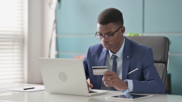 Молодой африканский бизнесмен делает успешный онлайн-платеж на ноутбуке — стоковое видео