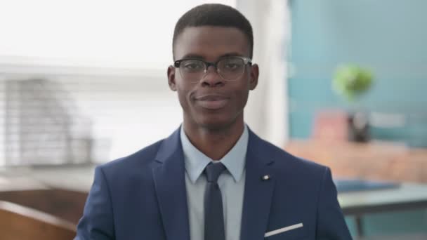 Jonge Afrikaanse zakenman glimlachend op camera — Stockvideo