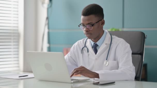Ofiste dizüstü bilgisayar kullanırken Genç Afrikalı Doktor İşaretini Gösteriyor — Stok video