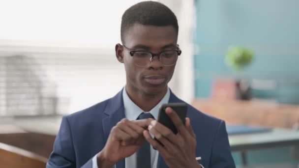 Giovane imprenditore africano che celebra su Smartphone — Video Stock