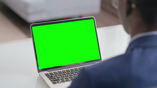 Jonge Afrikaanse zakenman met behulp van laptop met groene scherm — Stockvideo