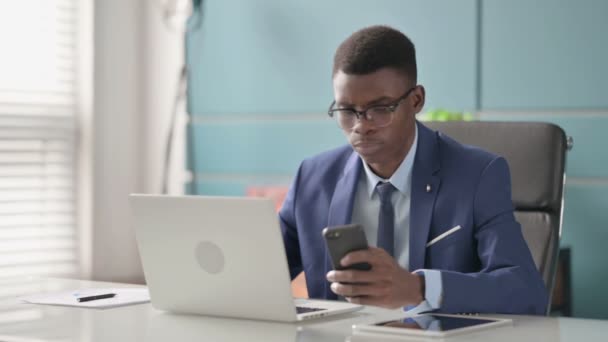 Молодой африканский бизнесмен, использующий Мбаппе в качестве топ-менеджера в офисе — стоковое видео