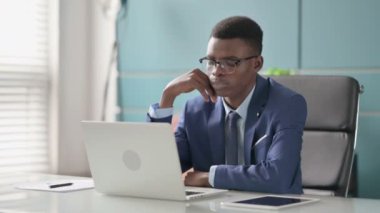 Genç Afrikalı İş Adamı Ofiste Dizüstü bilgisayarla çalışırken Düşünüyor