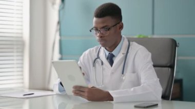 Ofiste otururken Tablet kullanan genç Afrikalı Doktor