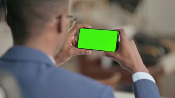 Mladý africký podnikatel při pohledu na Smartphone s Chroma Screen — Stock video