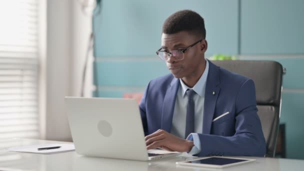 ラップトップの揺れ頭を持つ若いアフリカのビジネスマンはいサイン — ストック動画