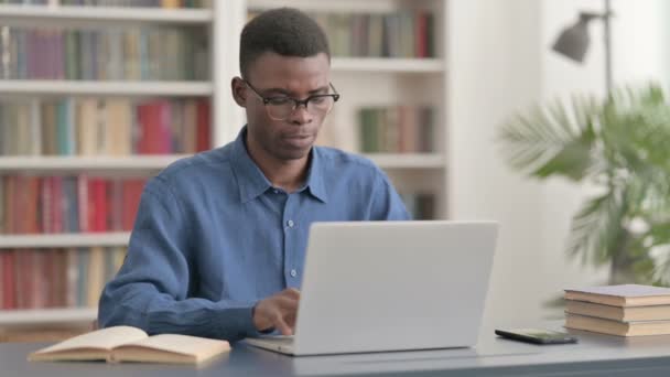 Jonge Afrikaanse man toont duimen omhoog tijdens het gebruik van laptop — Stockvideo