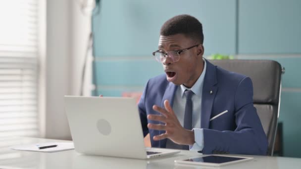 ラップトップを使用している間に損失に反応する若いアフリカのビジネスマン — ストック動画