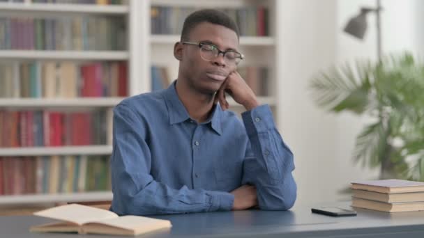 オフィスに座っている間に昼寝をするアフリカの若い男 — ストック動画