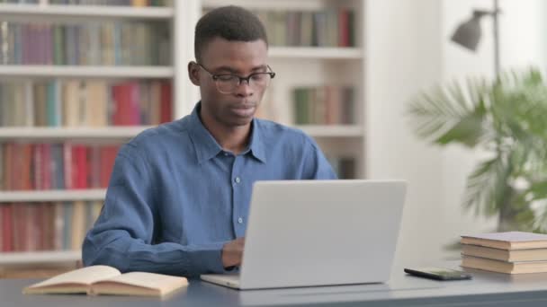 Het afwijzen van jonge Afrikaanse man in ontkenning tijdens het gebruik van laptop — Stockvideo