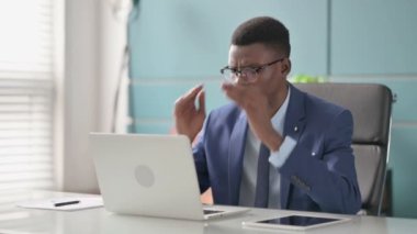 Genç Afrikalı İşadamı dizüstü bilgisayarla uğraşırken baş ağrısı çekiyor