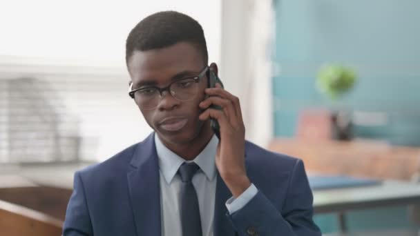 Jovem empresário africano conversando por telefone — Vídeo de Stock