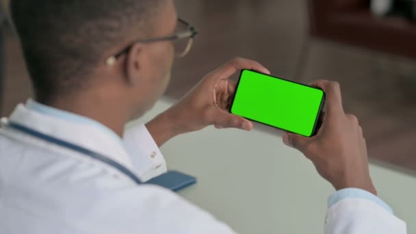Giovane medico africano guardando Smartphone con schermo cromato — Video Stock