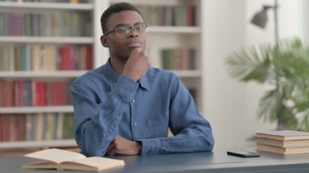 사무실에 앉아서 생각하는 관대 한 젊은 아프리카 남자 — 비디오