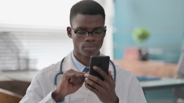 Młody afrykański lekarz za pomocą smartfona — Wideo stockowe