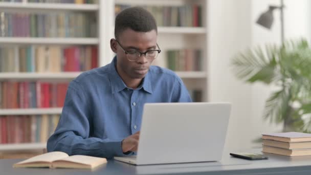 Jonge Afrikaanse man reageert op verlies tijdens het gebruik van laptop — Stockvideo
